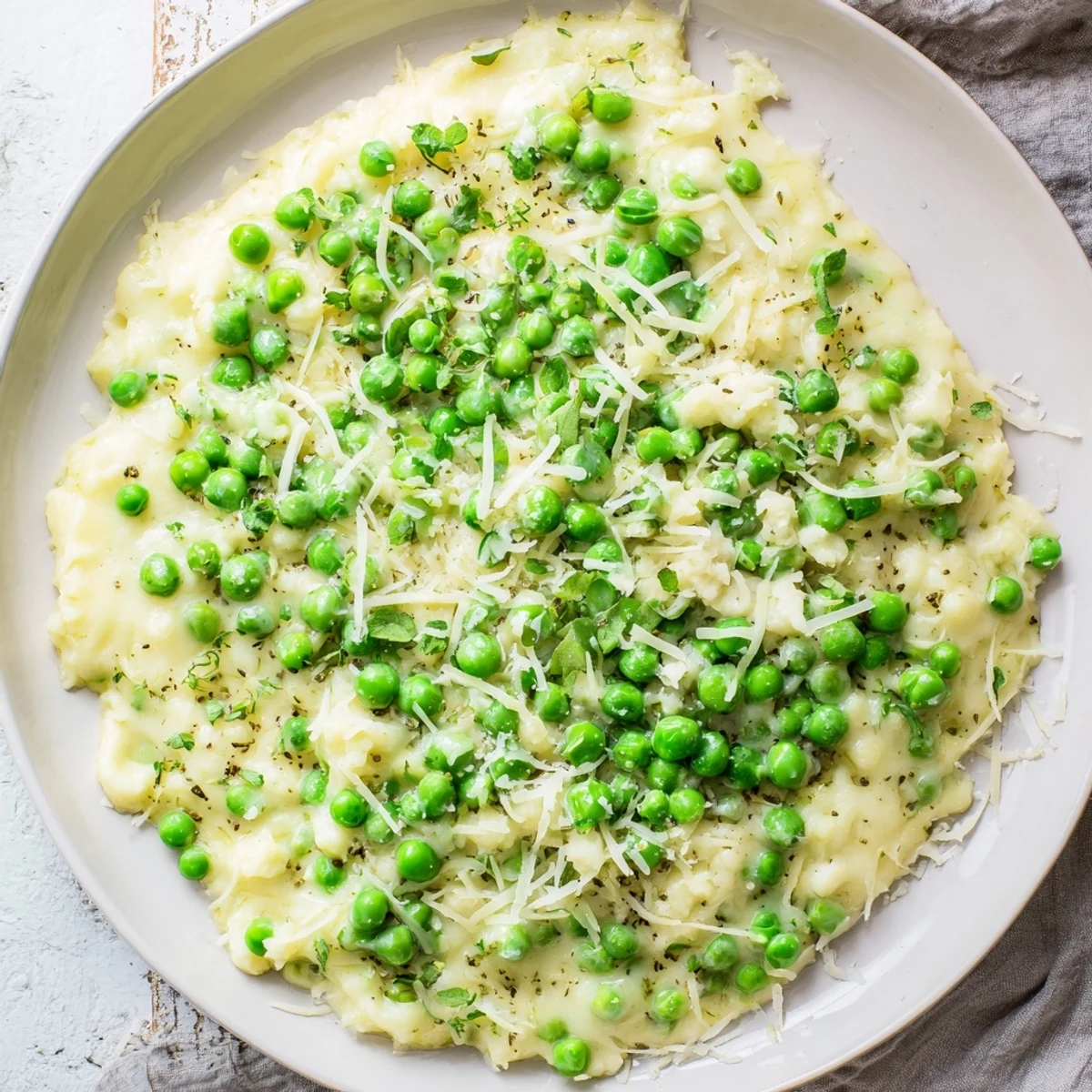 Creamy Parmesan Orzo with Green Peas, a comforting, one-pan Italian dish, topped with fresh parsley.