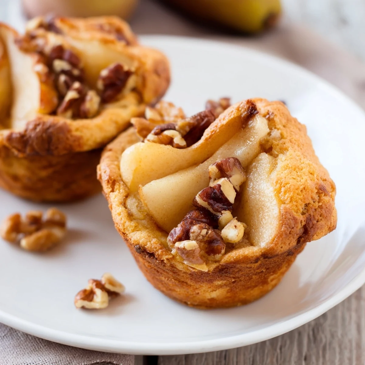 Golden-brown seasonal spiced pear and walnut muffins, fresh from the oven, ready to serve.