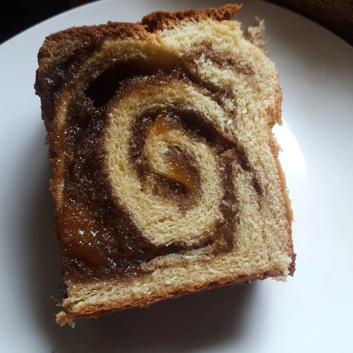 Golden brown Homemade Cinnamon Swirl Raisin Bread with visible swirls and sweet, plump raisins inside.