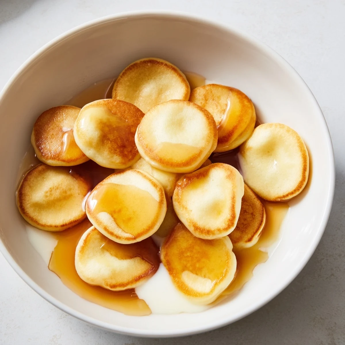 Miniature, perfectly cooked pancake cereal, offering a delightful, fun twist on your morning meal.