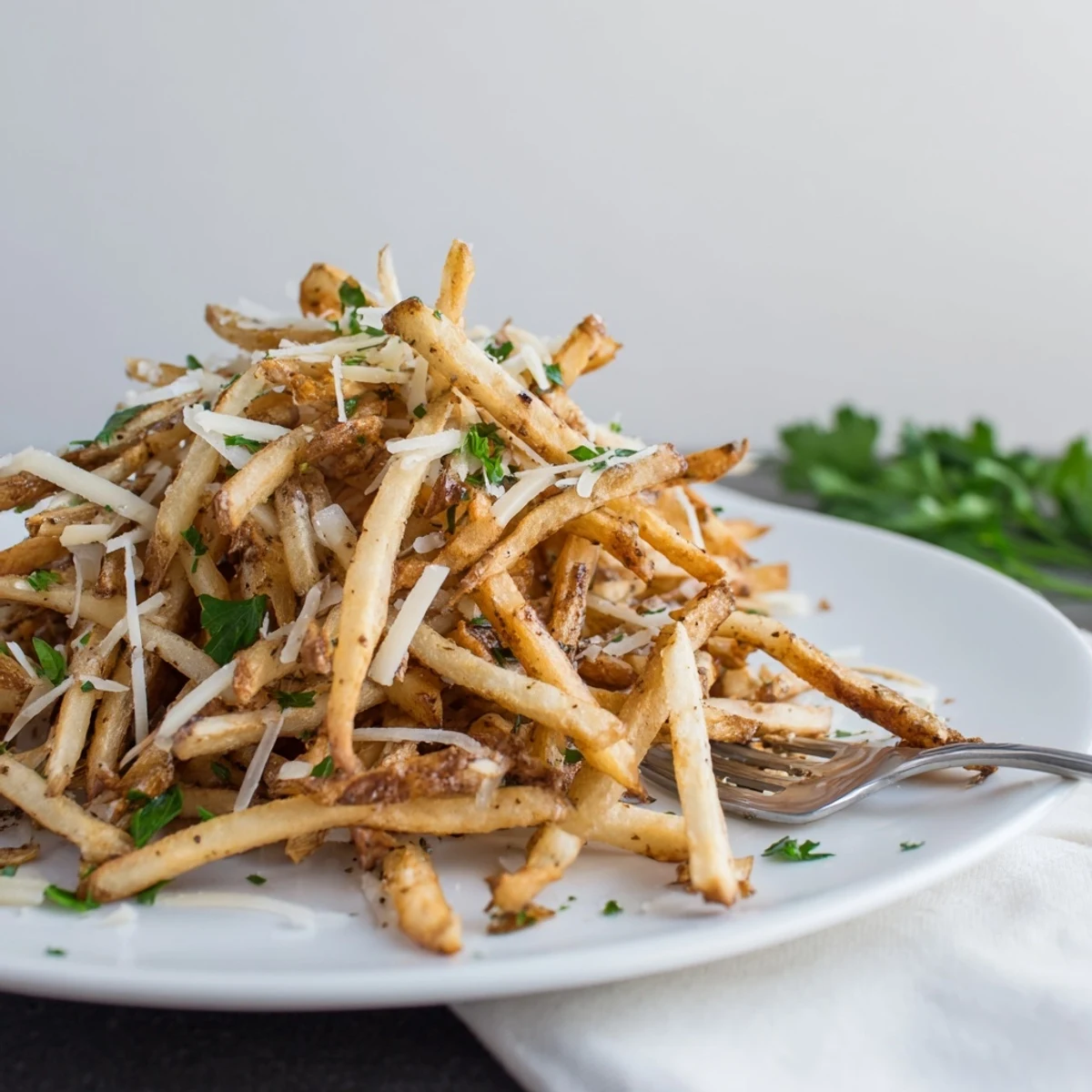 Golden-brown Truffle Parmesan Fries, perfectly crispy from the oven and garnished with fresh parsley.  