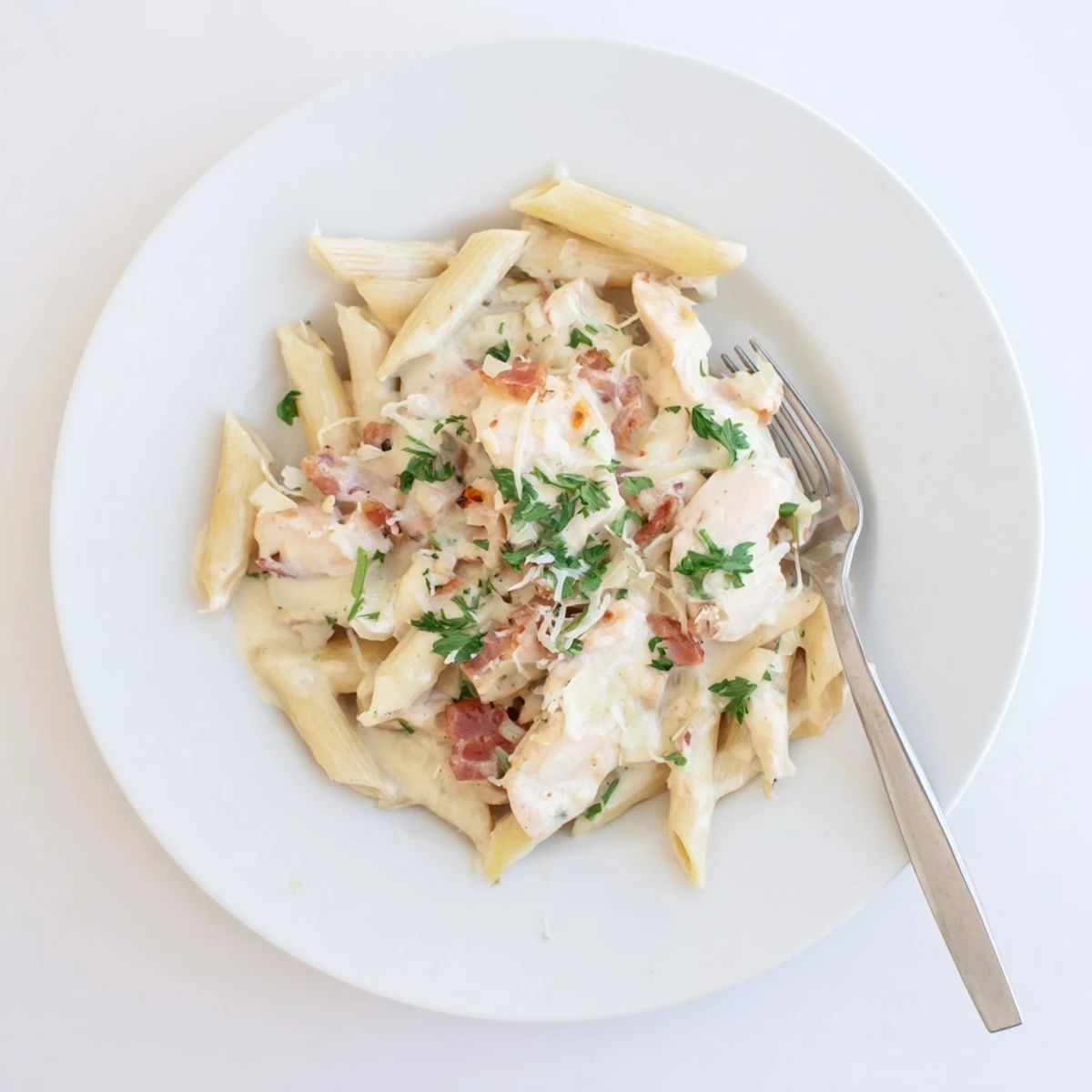 Steaming bowl of Creamy Chicken Bacon Penne featuring golden chicken, smoky bacon, and a luscious cream sauce.