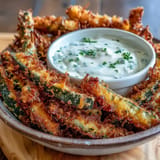 Golden, air-fried pickle fries with creamy spicy mayo, a perfect snack.