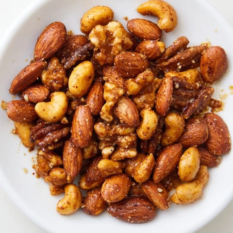 A bowl of Spiced Nuts Mix with cumin and paprika, served alongside a cheese board.