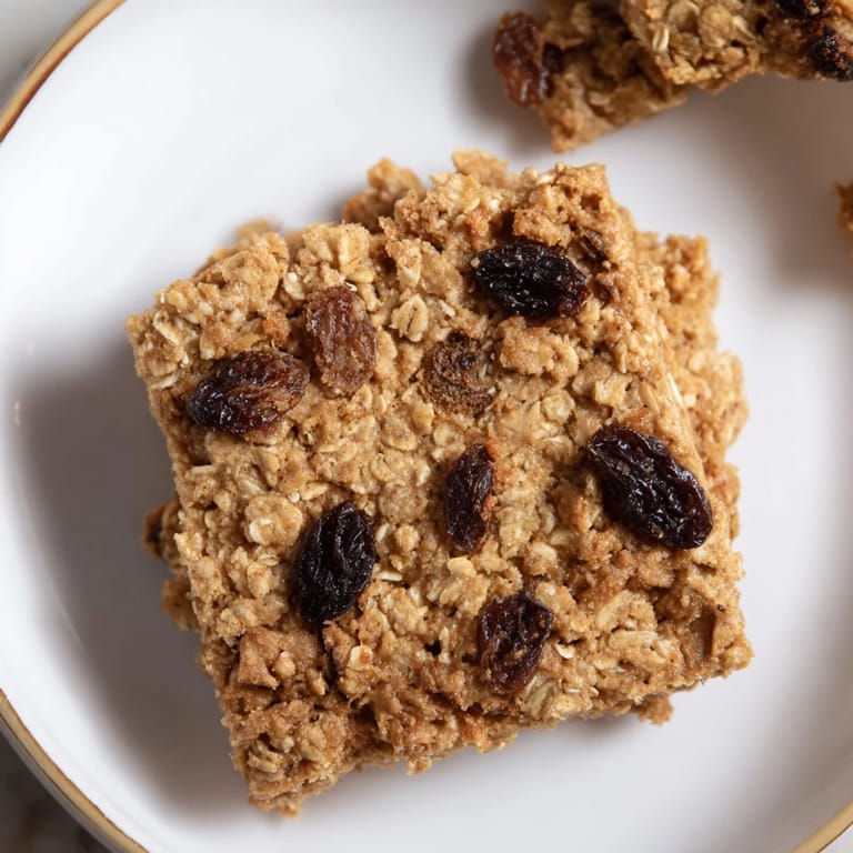 Warm, comforting image of a stack of soft-baked oatmeal raisin breakfast cookies, ideal with a morning coffee.