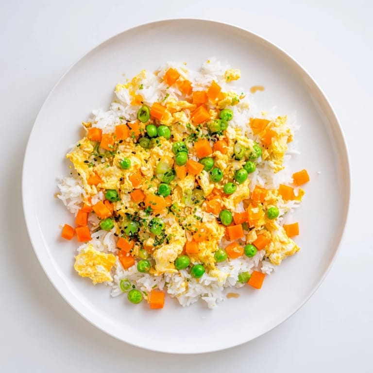 A steaming bowl of flavorful Egg Fried Rice, garnished with fresh scallions, ready to eat.