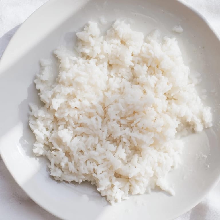 Steaming bowl of Coconut Jasmine Rice, light and fluffy, ideal for a vegan feast.