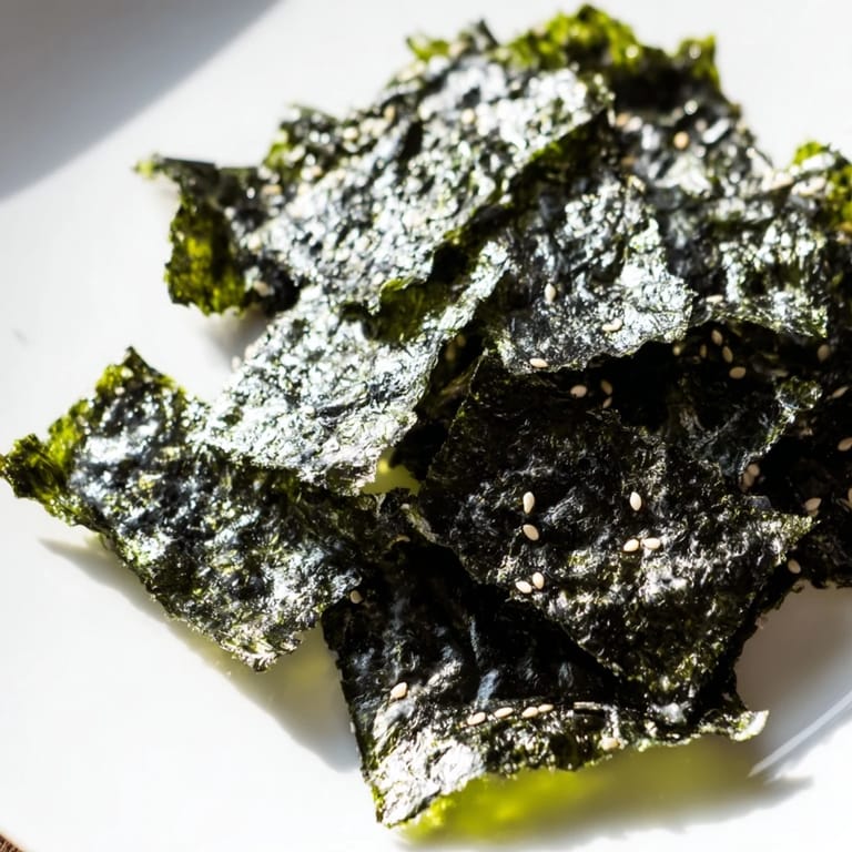 Close-up view of freshly roasted seaweed chips, seasoned with salt and sesame oil, ready to be enjoyed as a vegan, gluten-free snack.