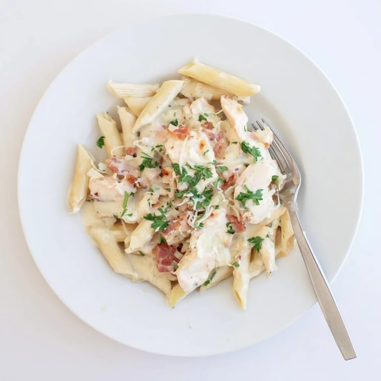 Steaming bowl of Creamy Chicken Bacon Penne featuring golden chicken, smoky bacon, and a luscious cream sauce.