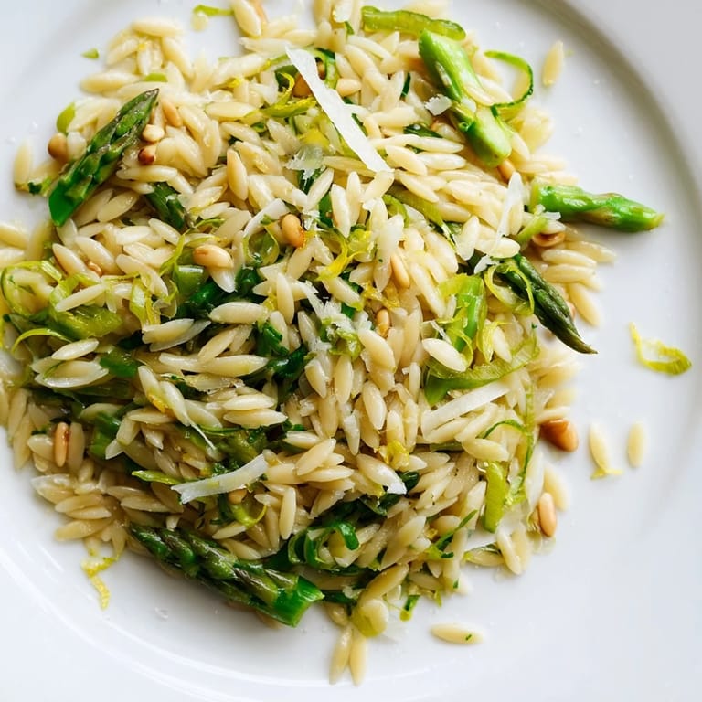 Bright and fresh, the Asparagus Lemon Orzo Salad features shaved spears, fluffy pasta, and pine nuts, tossed in a tangy lemon dressing for a light Mediterranean-inspired side dish.