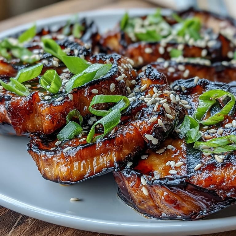 Silky roasted Japanese eggplant showcasing a beautiful, savory miso glaze and fresh green onions.