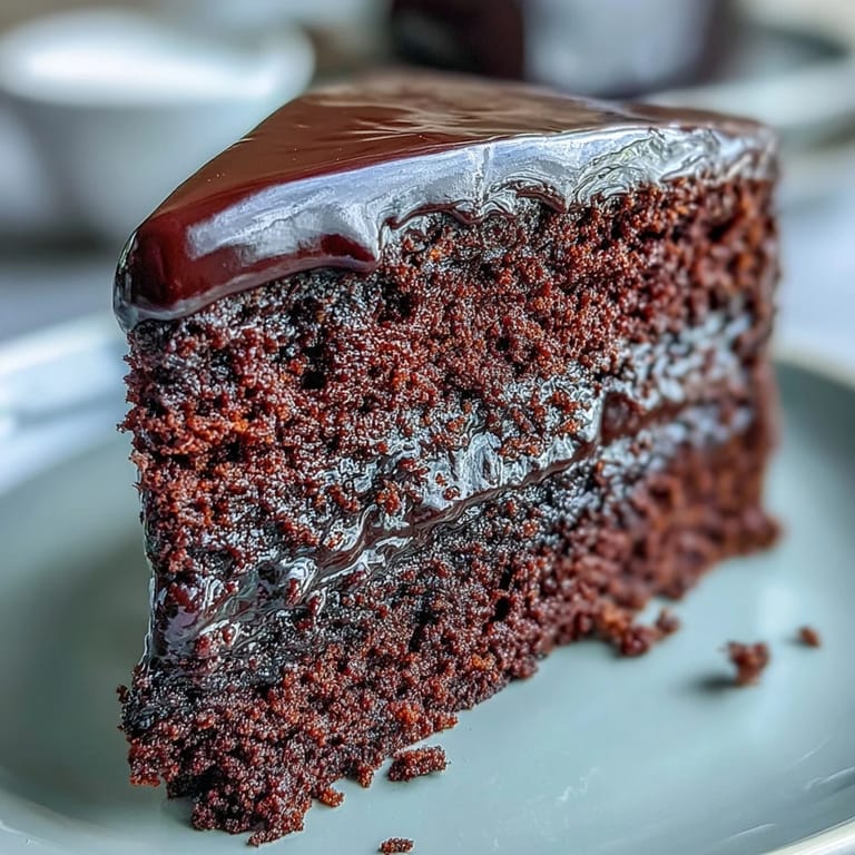 Homemade Easy Chocolate Fudge Cake with rich dark chocolate layers and smooth icing, ready to slice and serve.