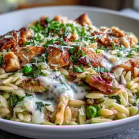 Creamy One-Pot Lemon Orzo with tender chicken and sweet peas, brightened by fresh lemon zest and parsley.